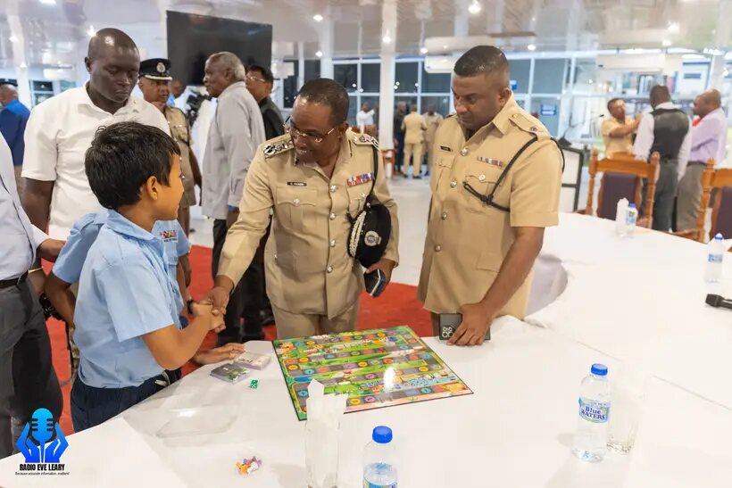 Landon shaking hands with a police officer beside the board
